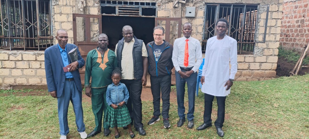 Foundation leaders and members standing outside the stone church building